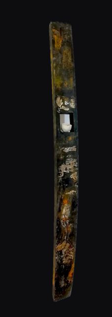 Petite douelle sombre aux reflets ocre, une pièce de porcelaine blanche insérée dans une niche